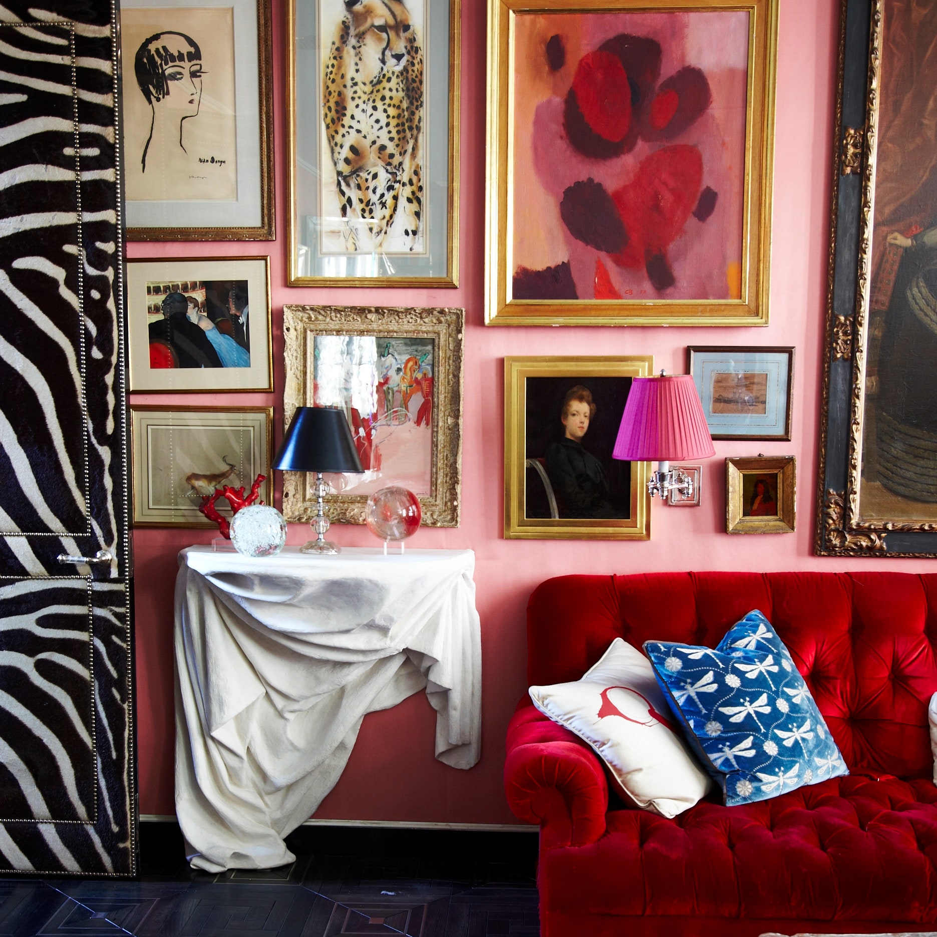 red couch in pink room with zebra wall