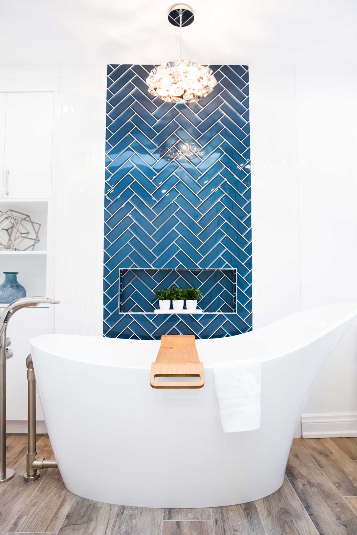standalone bathtub with blue herrinbone tile